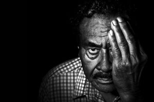 Man covering eye to do eye exercises